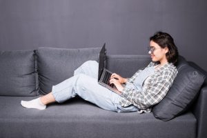 beautiful-young-brunette-woman-home-sitting-sofa-settee-using-her-laptop-computer-smiling_231208-5663
